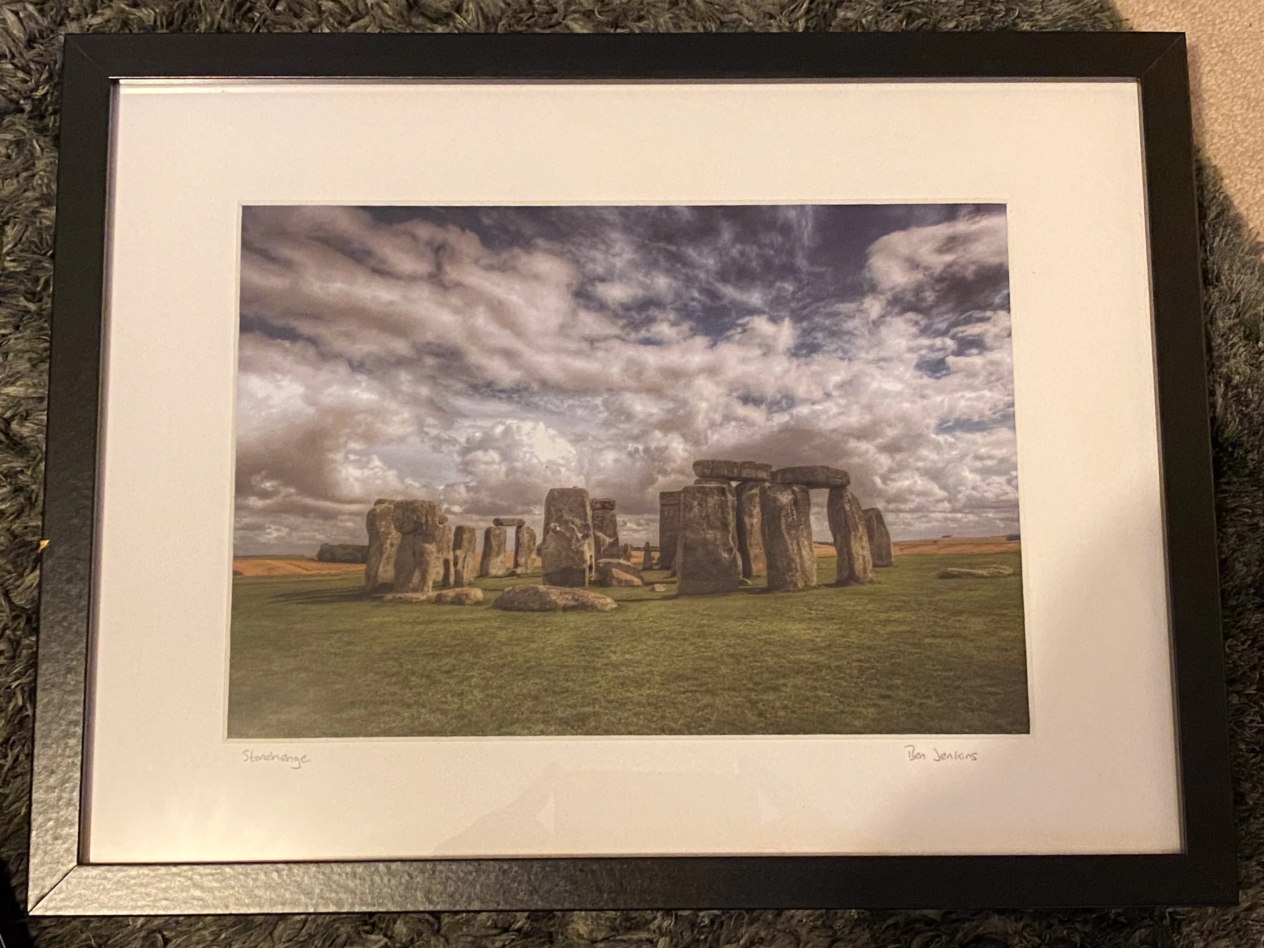 Mounted and framed photograph of Stonehenge beneath a dramatic sky
